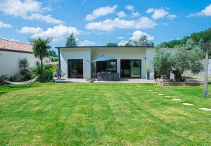 una casa con un prato davanti di La Villa Ô Bois - Billard & Baby-Foot - face à la forêt a Séméac