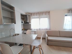 uma cozinha e sala de estar com mesa e cadeiras em Apartamentos Turísticos Pontepedriña by Bossh! Hotels em Santiago de Compostela