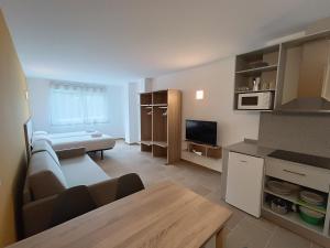 pequeña sala de estar con sofá y cocina en Apartamentos Turísticos Pontepedriña by Bossh! Hotels, en Santiago de Compostela