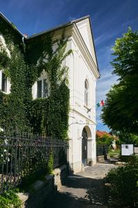 a white building with ivy growing on the side of it at Barta Pince Rákóczi Lakosztályok in Mád