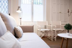a living room with a white couch and a table at Apartamento en casa centenaria, Parque M.ªCristina in Getxo +8 photos