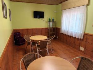 a room with tables and chairs and a tv at A CONDA in Arzúa