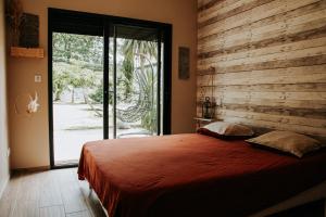 1 dormitorio con 1 cama grande y pared de madera en La Villa Ô Bois - Billard & Baby-Foot - face à la forêt en Séméac