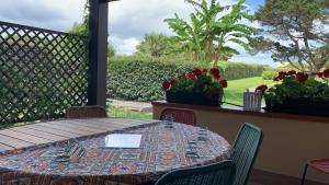 a table on a porch with a view of a garden at Pelosa - Capo Falcone Excellent Apartment in Stintino