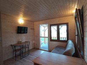 a living room with a couch and a table at Wypoczynek nad stawami in Sobiechy