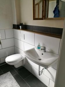 uma casa de banho com um lavatório branco e um WC. em Stadtvilla em Kiel