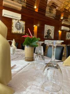 a table in a restaurant with wine glasses on it at Bano Palace Hotel in Douala