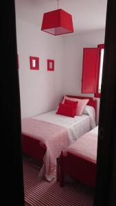 a bedroom with two beds with red pillows at A Casiña de Carmen in Boiro +15 photos