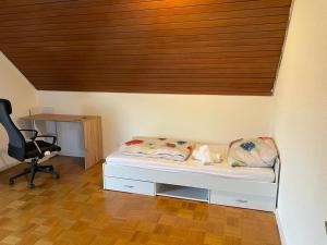 a bedroom with a bed and a desk and a chair at FlyHigh Apartment Stuttgart VS2 in Stuttgart