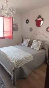 a bedroom with a white bed and a chandelier at A Casiña de Carmen in Boiro