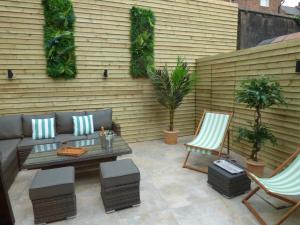 a patio with a couch and two chairs and a table at Historic City Centre Town House in Chester