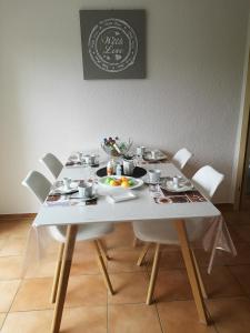 a white table with plates of food on it at 3 Zi Ferienwohnung mit Erholungsfaktor Schwarzwald Bodensee in Aldingen