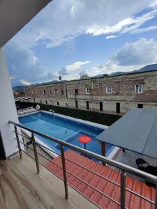 une piscine avec une table sur un balcon dans l'établissement Unique, à Gramsh