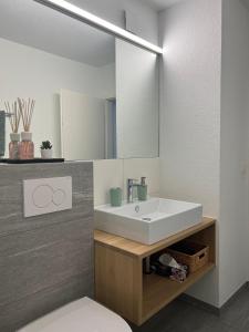 ein Bad mit einem Waschbecken und einem Spiegel in der Unterkunft Ferienwohnung 405 Haus Allod in Lenzerheide