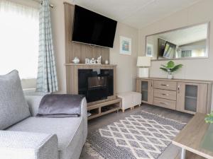 a living room with a couch and a flat screen tv at No 4 Fistral in Newquay