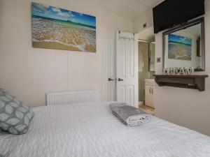 a bedroom with a bed and a television on the wall at No 4 Fistral in Newquay