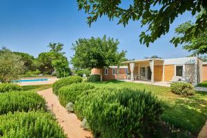 ein Haus mit einem Garten und einem Pool in der Unterkunft Camping Park Umag Mobile Homes in Umag