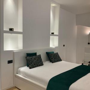 a bedroom with a white bed with green pillows at Loft Milano Manifatture 2 in Milan