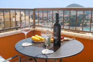 einen Tisch mit einer Flasche Wein und zwei Gläsern in der Unterkunft Azure Horizon in Dubrovnik