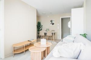 a living room with a couch and a table at Stay Urban - Scandinavian Comfort with Private Balcony in Bergen