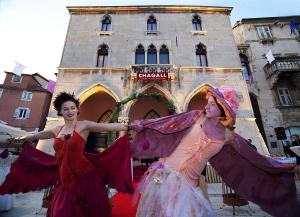 dos mujeres vestidas con trajes parados frente a un edificio en Central Jardin Guest House Split en Split