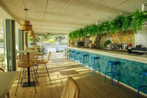 un bar con taburetes azules y una piscina en Alannia Costa Dorada, en Platja de l’Almadrava