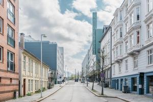 an empty street in a city with buildings at Stay Urban - Scandinavian Comfort with Private Balcony in Bergen