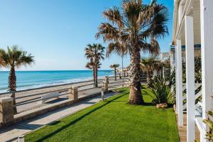 a house with a fence and palm trees on the beach at Alannia Costa Dorada in Platja de l’Almadrava