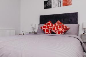 a bedroom with a large bed with red and white pillows at Sherwood Hotel in Margate