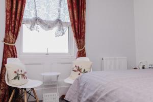 een slaapkamer met een bed en 2 stoelen en een raam bij Sherwood Hotel in Margate