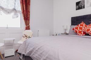 a bedroom with a large bed with red and white pillows at Sherwood Hotel in Margate