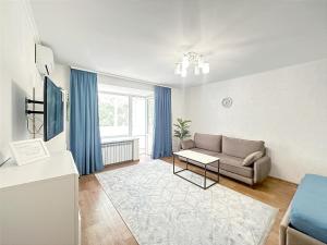 a living room with a couch and a table at 1 кімнатні просторі апартаменти біля Сіті- центру 2 поверх 9 поверхового будинку in Mykolaiv