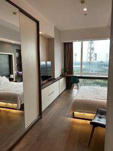 a bedroom with a mirror and a bed and a desk at U Residence 2 Studio Apartment POOL VIEW in Tangerang