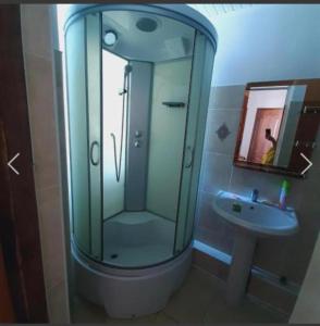 a bathroom with a glass shower and a sink at Бухта гостевой дом in Cholpon-Ata