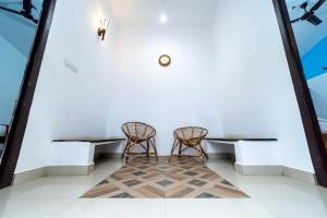 two wicker chairs sitting next to a wall at KBS Sree Paradise Kodai in Kodaikānāl