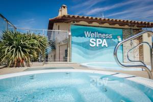a hot tub in front of a building with a wellness spa sign at Alannia Costa Dorada in Platja de l’Almadrava
