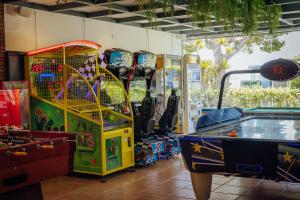 a room with several arcade games and a pool table at Alannia Costa Dorada in Platja de l’Almadrava