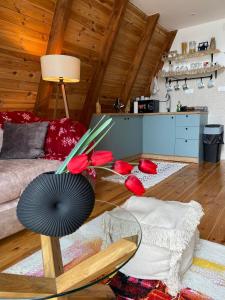 a living room with a couch and a table with red flowers at WoodMood in Žabljak