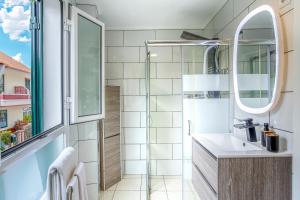 uma casa de banho com um lavatório e um espelho em Mateus House - Porto da Cruz Center em Porto da Cruz