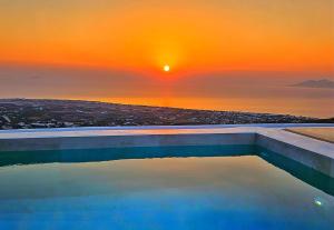 a swimming pool with a sunset in the background at Martynou View in Pirgos