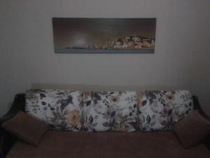 a couch sitting in a living room under a painting at Studio Apartment in Durrës