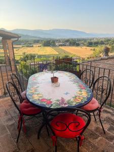 a table and chairs on a balcony with a view at A Room With A View-Spello in Spello