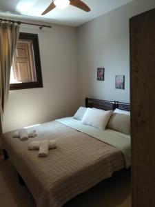 a bedroom with a bed with two towels on it at Κατηγιώργης Ξενώνας Ρεγγίνα in Agios Georgios
