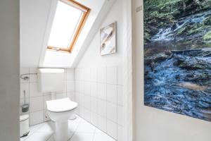 a bathroom with a toilet and a painting on the wall at Ferienwohnung Sillack in Dresden