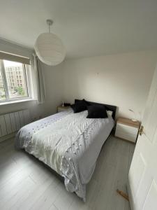 a bedroom with a bed with a white comforter and a window at 2BD Flat with Views of Canary Wharf - Rotherhithe in London