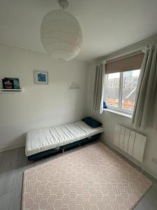 a room with a bed and a window and a rug at 2BD Flat with Views of Canary Wharf - Rotherhithe in London