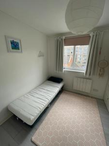 a bed in a room with a window and a rug at 2BD Flat with Views of Canary Wharf - Rotherhithe in London