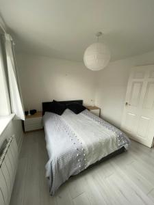 a bedroom with a white bed and a white ceiling at 2BD Flat with Views of Canary Wharf - Rotherhithe in London