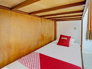 - un lit avec un oreiller rouge dans l'établissement OYO 92736 Bougenville Rover, à Lamongan
