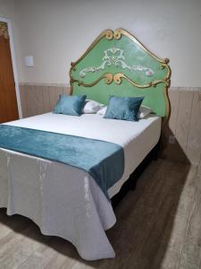 a bedroom with a large bed with a green headboard at Suite Queen D'Arte in Florianópolis